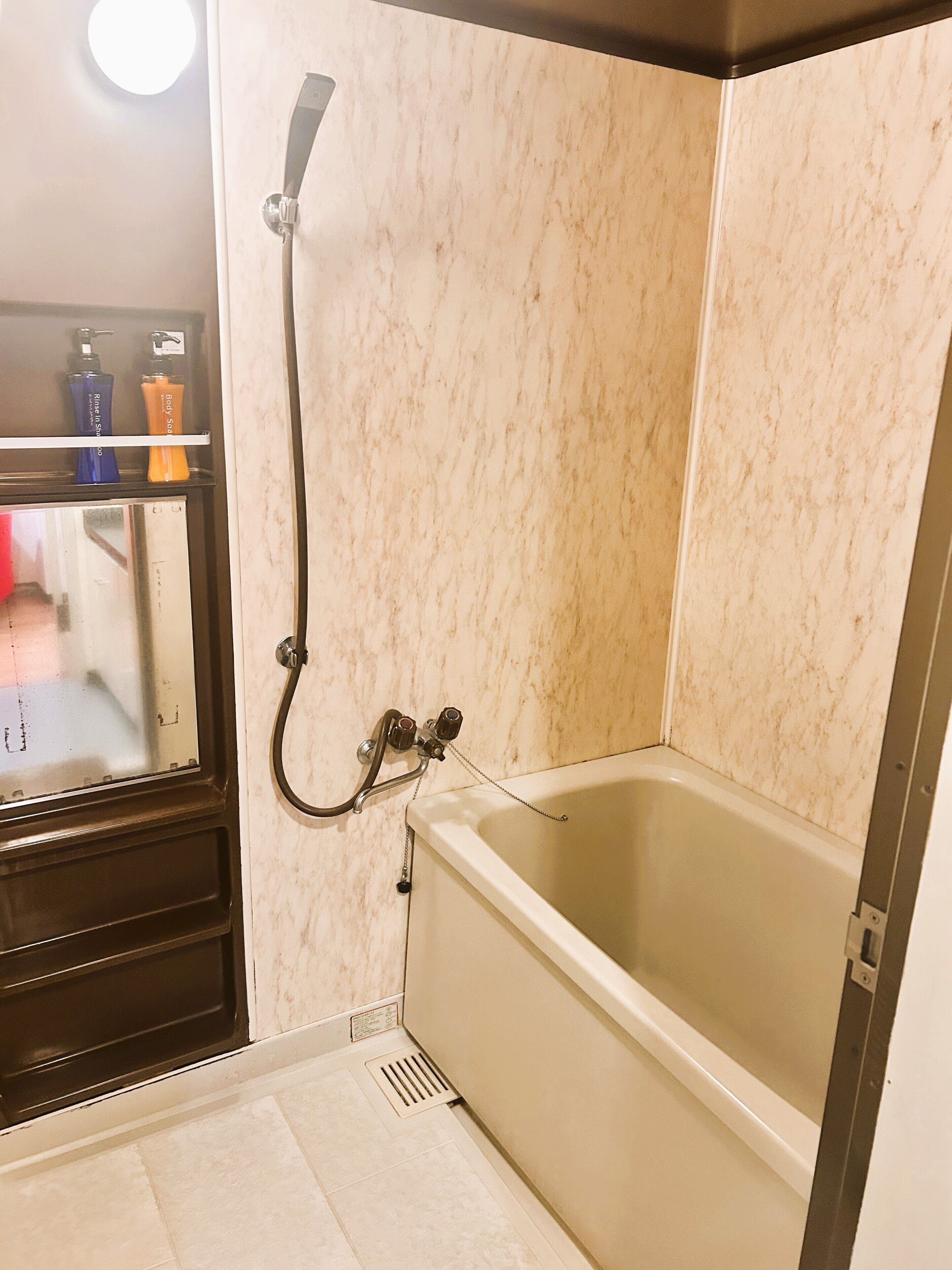 A bathroom with a bathtub, a shower, and a mirror.