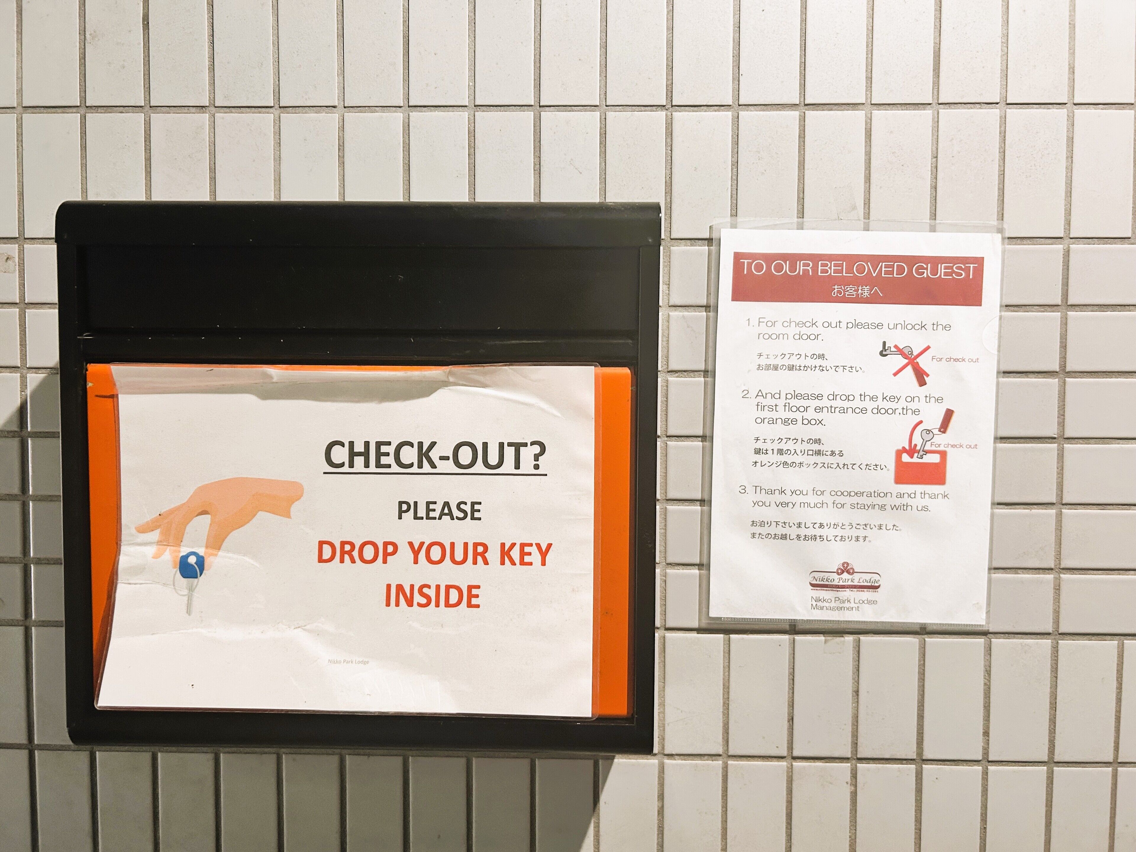 A sign instructing guests to check out by dropping their key inside.