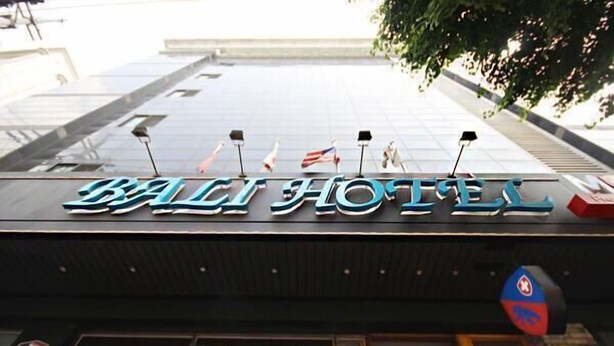 Segnaletica dell'Hotel Bali con bandiere e un logo blu.