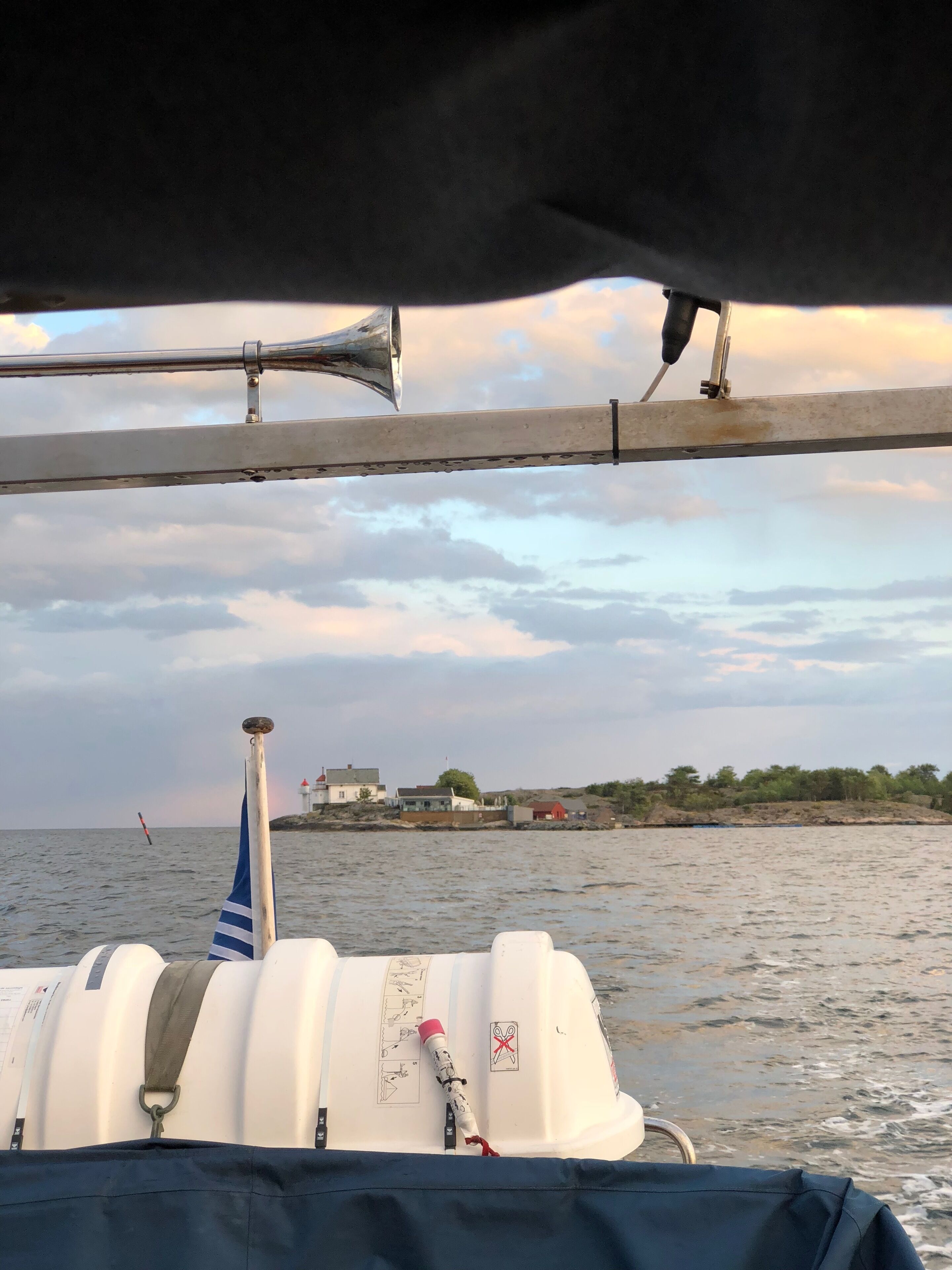 Interior de un barco con vista al mar y una costa lejana con edificios.