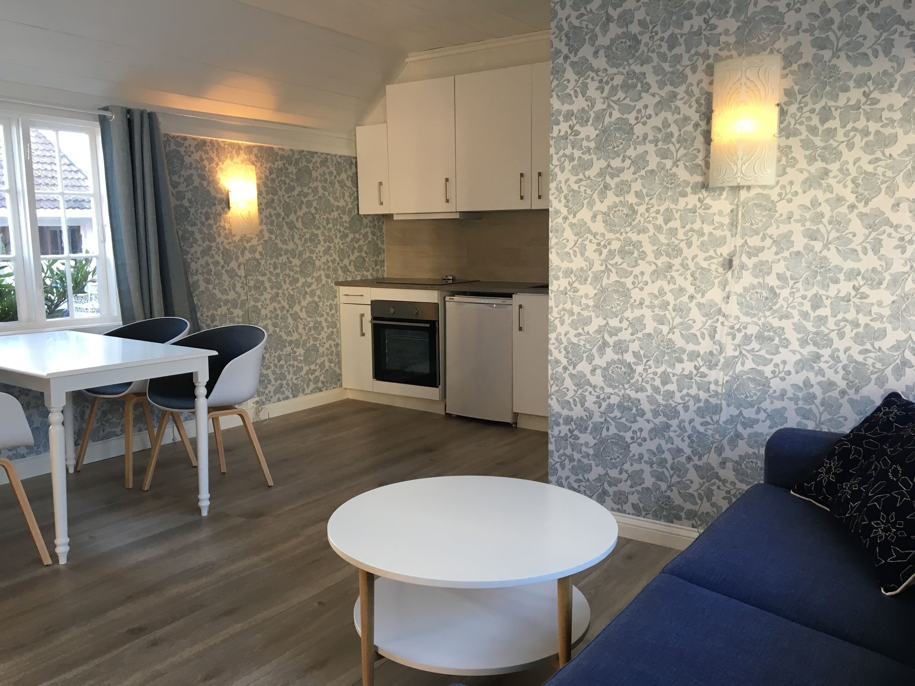 A compact living space with a dining area, kitchenette, and seating area.