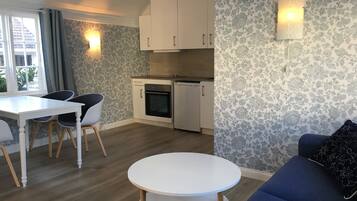 A compact living space with a dining area, kitchenette, and seating area.