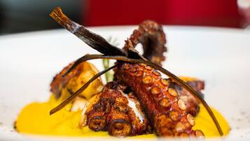 Un plato con pulpo y salsa amarilla.