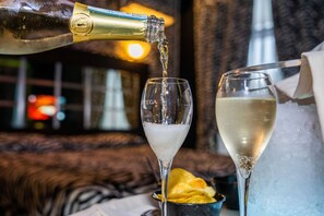 A bottle of champagne being poured into a glass. - Hotel Marcantonio (Giugliano in Campania)