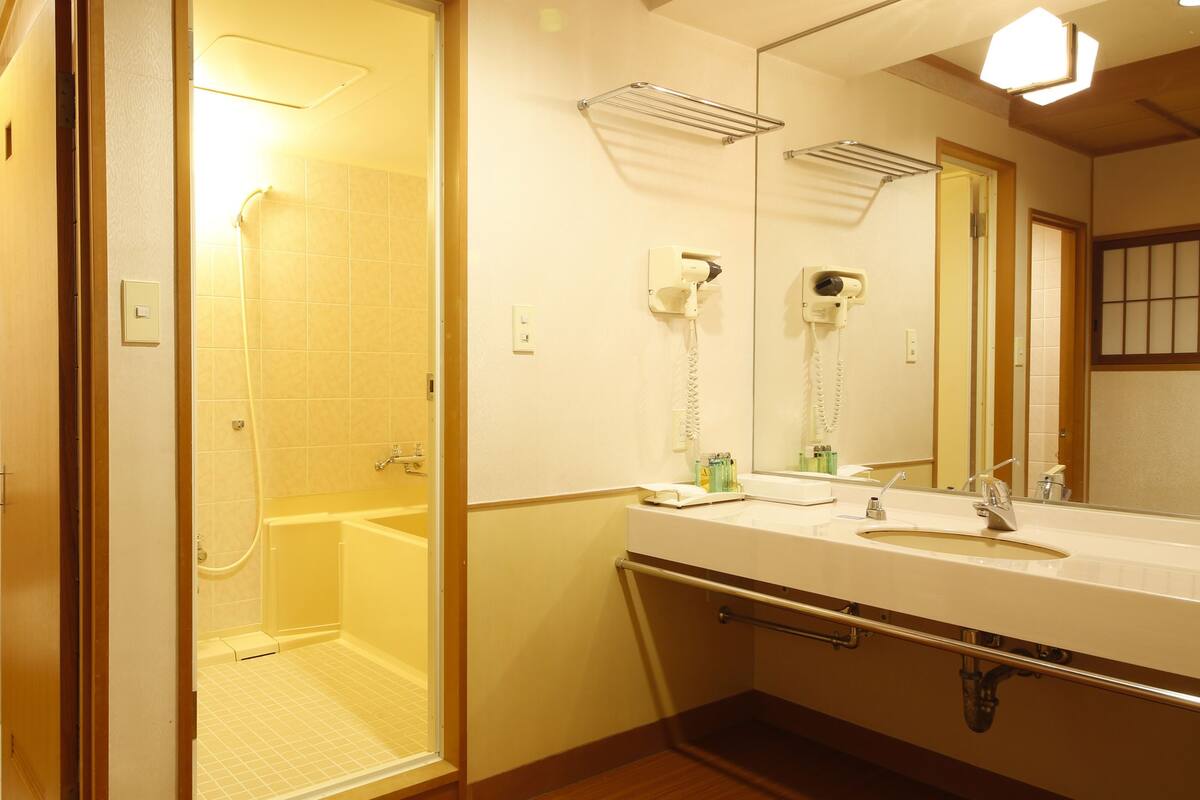 A bathroom with a toilet, shower, and sink.
