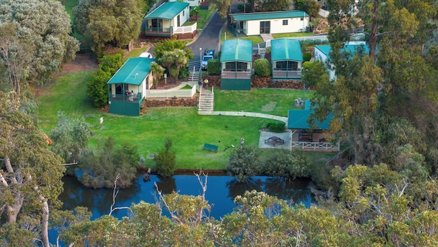 A residential area with multiple houses, a small stream, and a bridge. - Riverview Tourist Park (Margaret River)