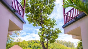 A pathway leading to a building with a tree in the center, surrounded by lush greenery. - Crystal Wild Resort Panwa Phuket (Wichit)