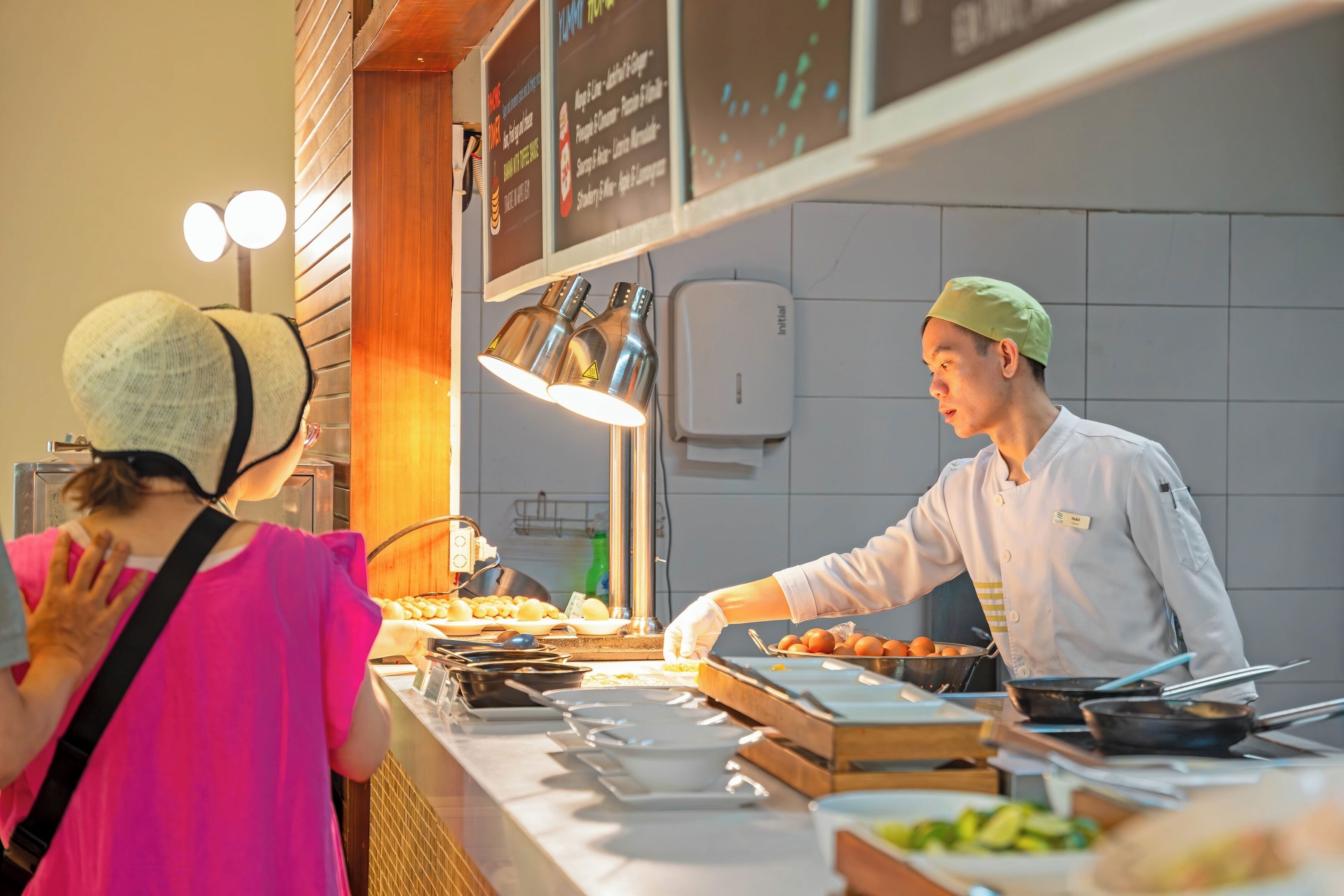 A buffet setup with various food items and a person serving food.