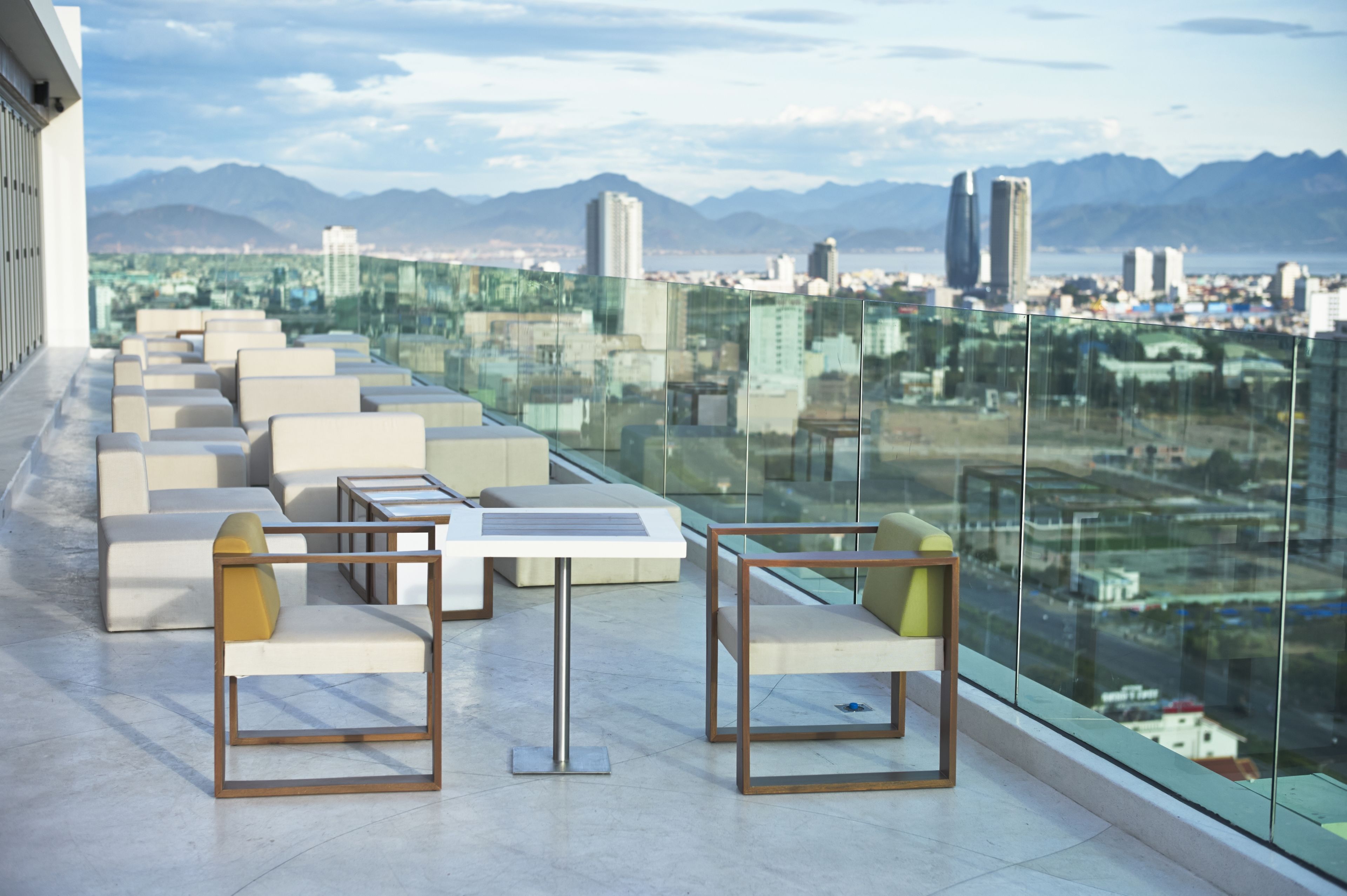A rooftop terrace with modern seating and a panoramic city view.