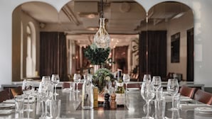 A dining table set with wine glasses, bottles, and a centerpiece. - Miss Clara by Nobis, Stockholm, a Member of Design Hotels (Stockholm)