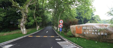 Een weg die leidt naar een bord met daarop Millennium Resort.