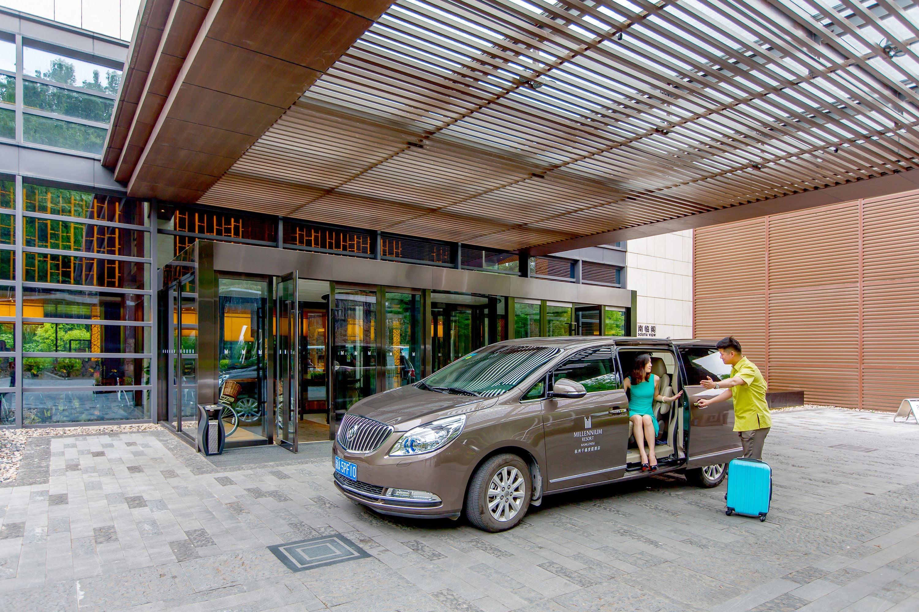 A modern building entrance with a car parked in front.