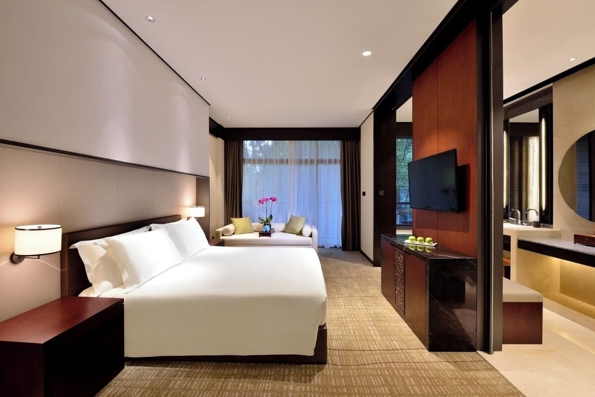 Une chambre d’hôtel moderne équipée d’un grand lit, d’un bureau, d’une télévision et d’une salle de bain.