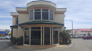A two-story building with a corner entrance, large windows, and a tiled roof. - Beach Front Motel Napier (Napier)