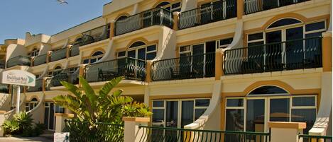 A multi-story hotel with balconies, large windows, and a sign indicating it is the Beach Front Motel.