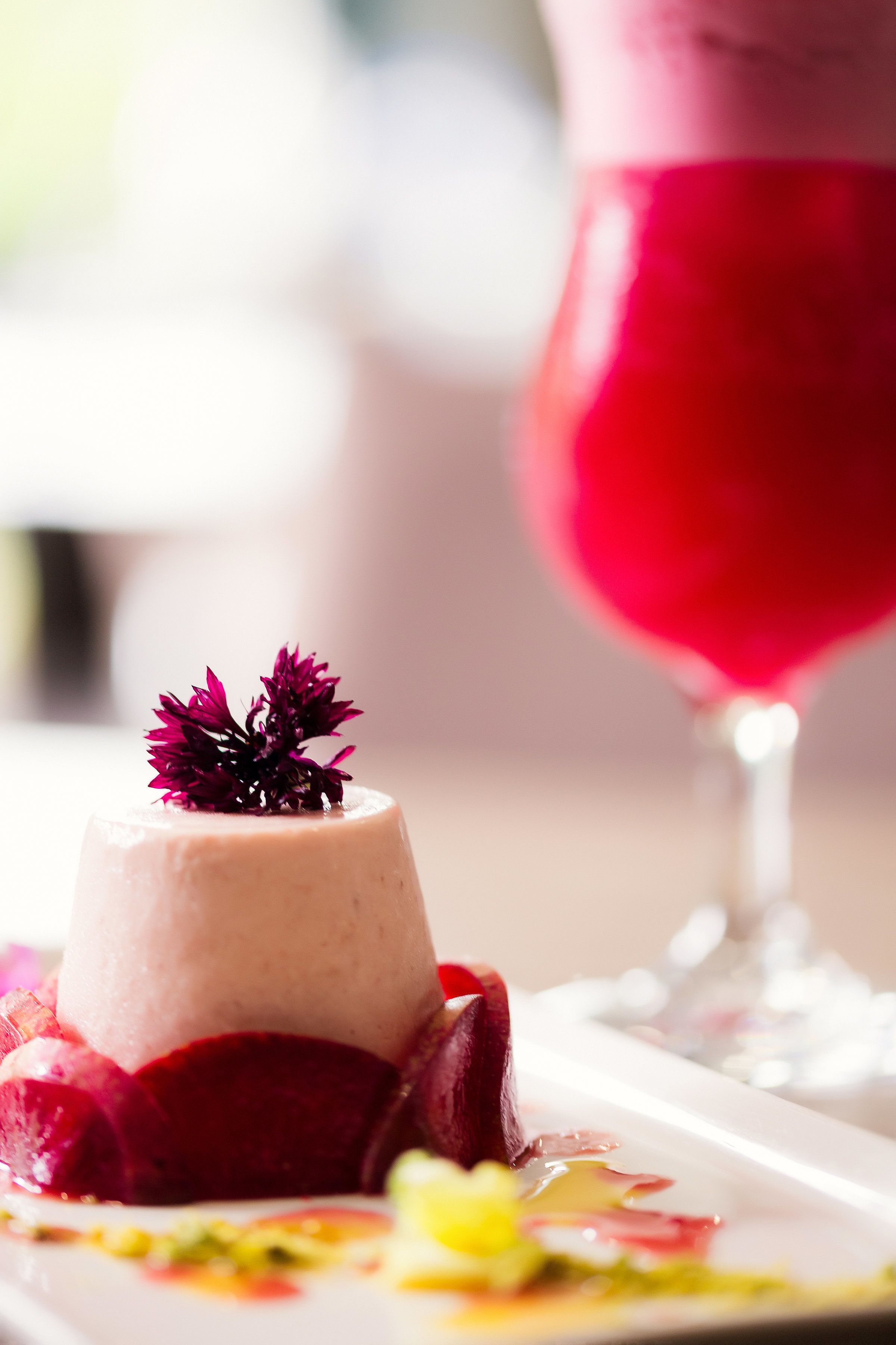 A dessert with a red drink in the background.