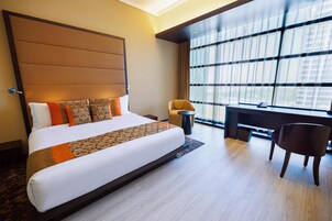 Una habitación de hotel con una cama grande, un escritorio y una silla.