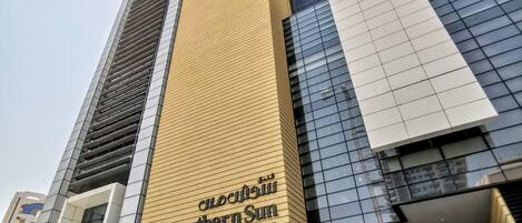 Un edificio de hotel alto con fachada dorada y un letrero que dice "Southern Sum Hotel".