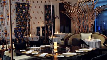 A dining area with a long table set for a meal, surrounded by chairs.