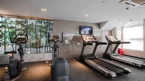 A modern gym with stationary bikes, an elliptical, and treadmills. - Modena by Fraser New District Wuxi (Wuxi)