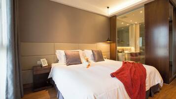A modern hotel room with a large bed, a nightstand, and a mirror.