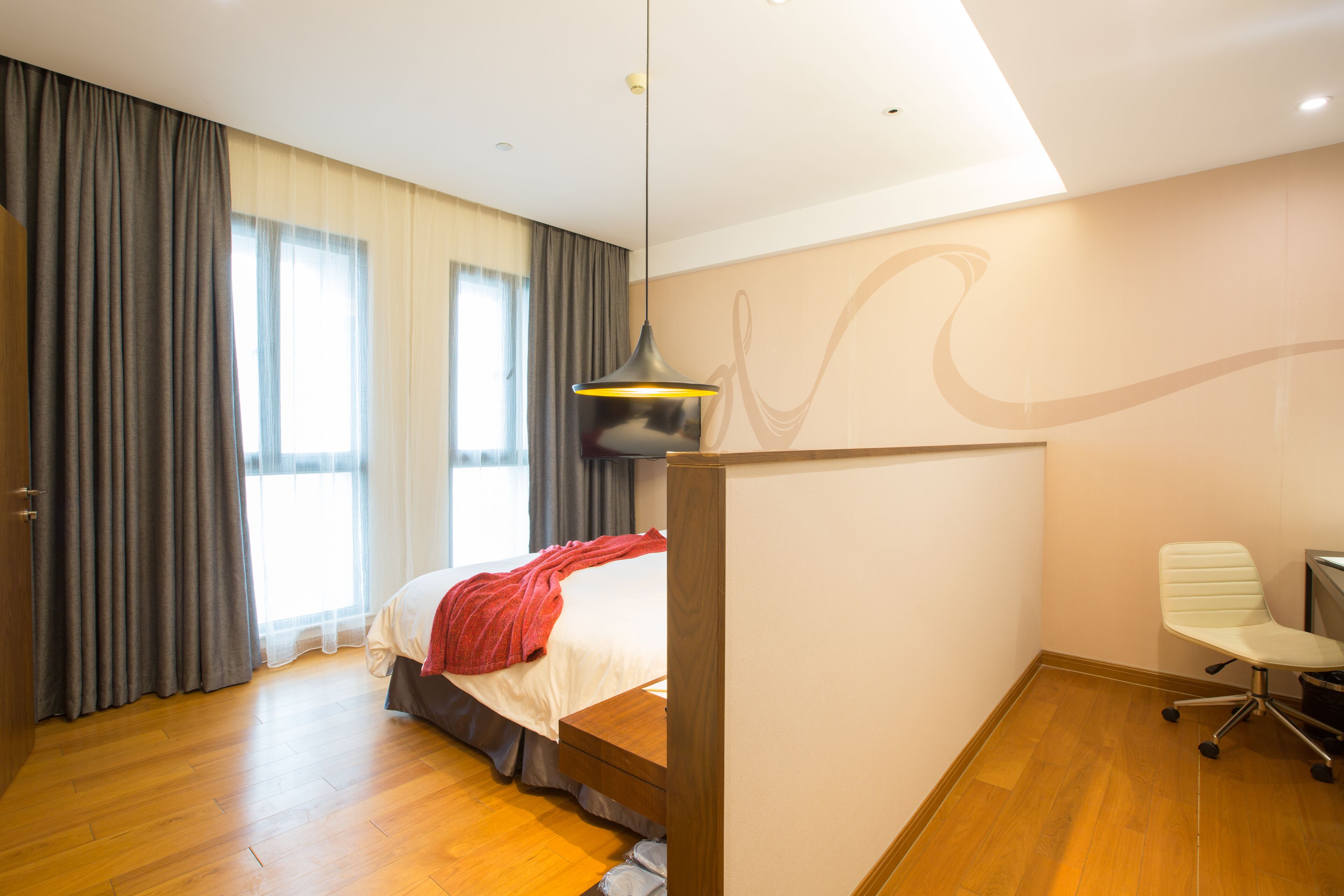 Een moderne hotelkamer met een groot bed, een bureau en een stoel.