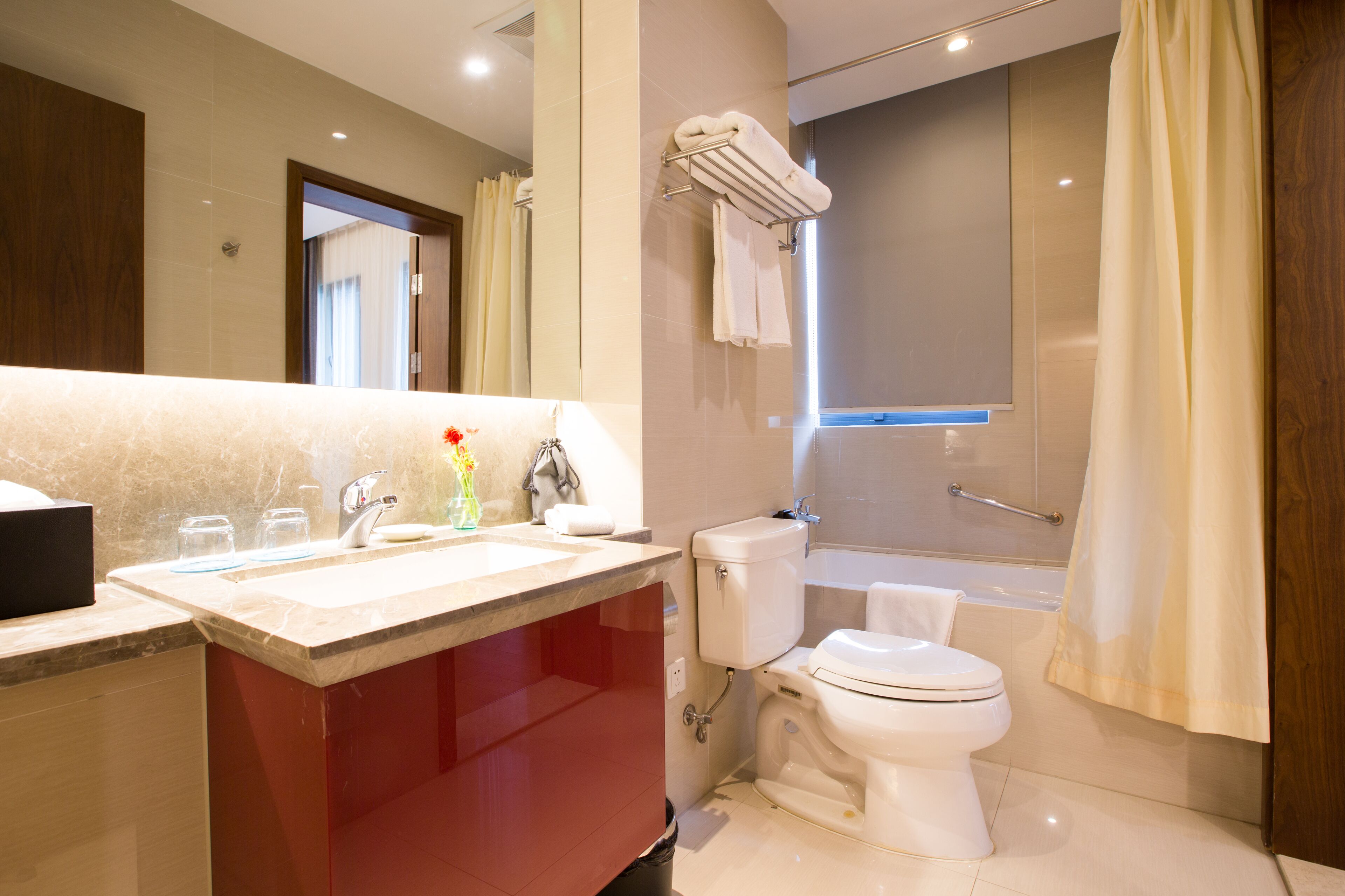 Un baño moderno con lavamanos de mármol, inodoro, bañera y ducha.