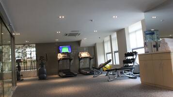 A gym with treadmills, a stationary bike, and a rowing machine.