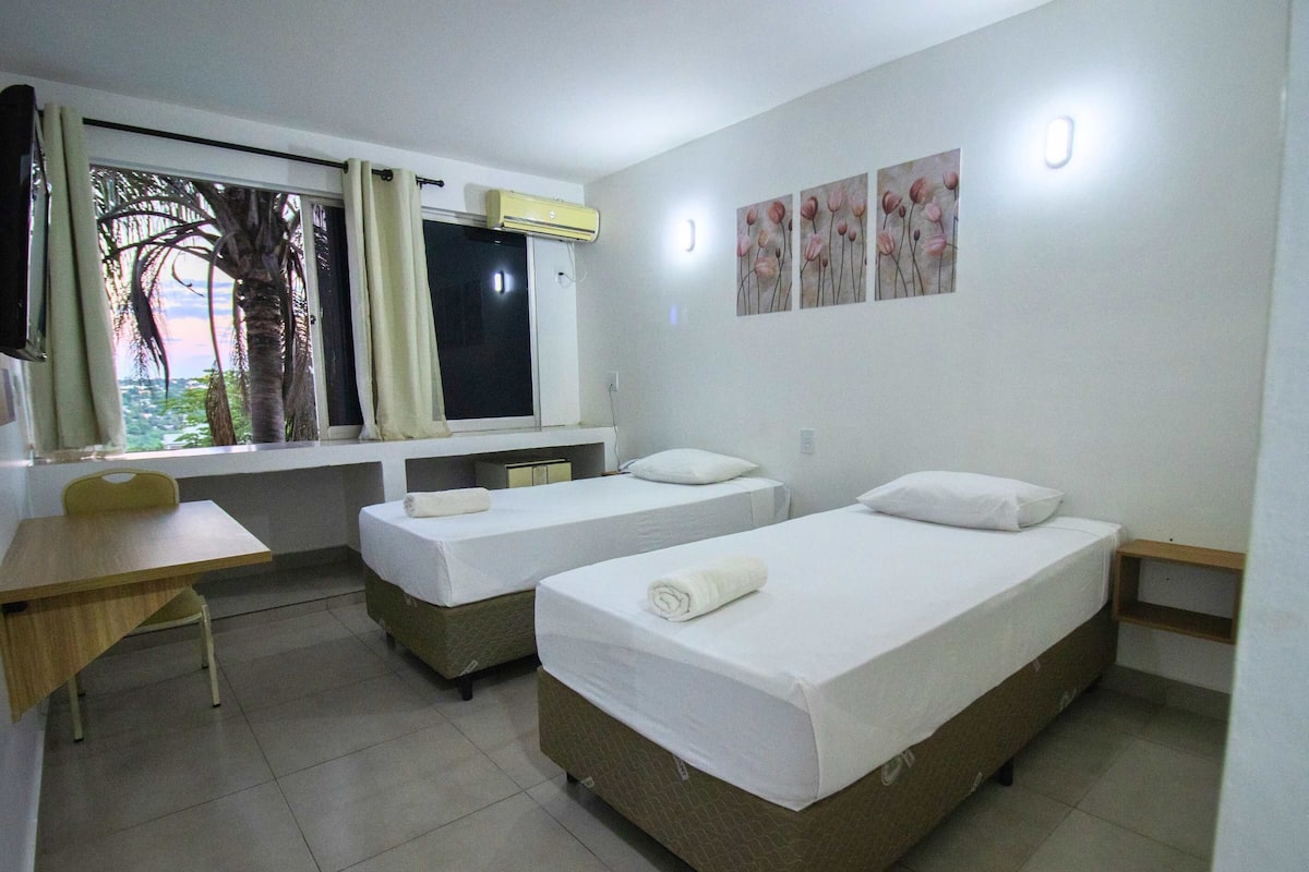 Quarto duplo, 2 camas de solteiro | Frigobar, cortinas blackout, Wi-Fi de cortesia, roupa de cama