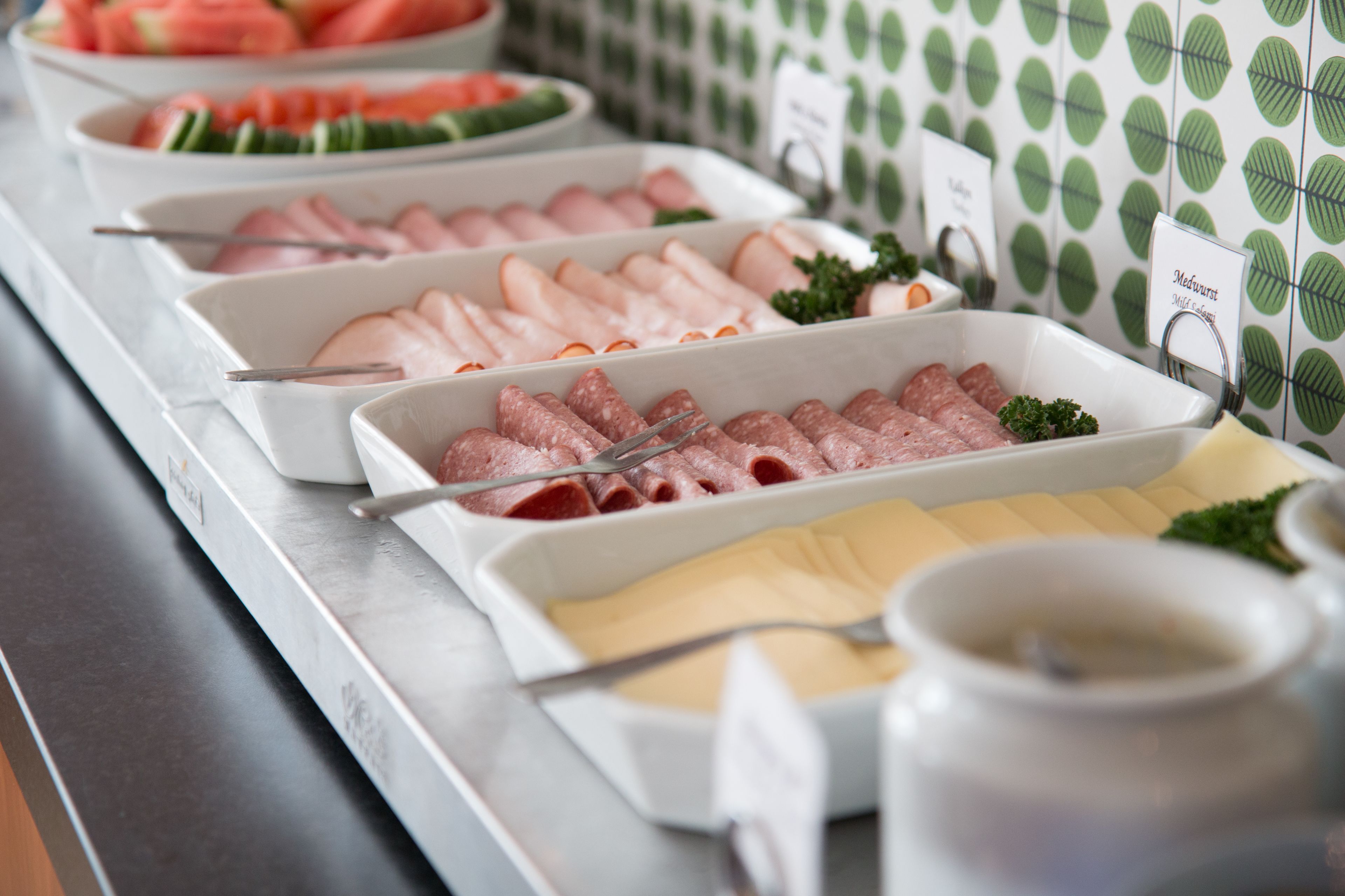 A buffet with various food options including sliced meats and vegetables.