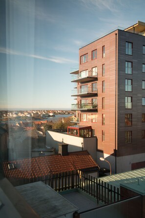 Un edificio moderno con varios balcones y vistas a un río y una ciudad.
