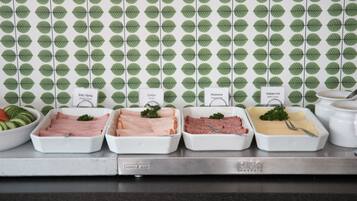 A buffet with various meat dishes labeled, including 'Smoked Ham', 'Kalkon Turkey', 'Medwurst', and 'Elamier Out'.