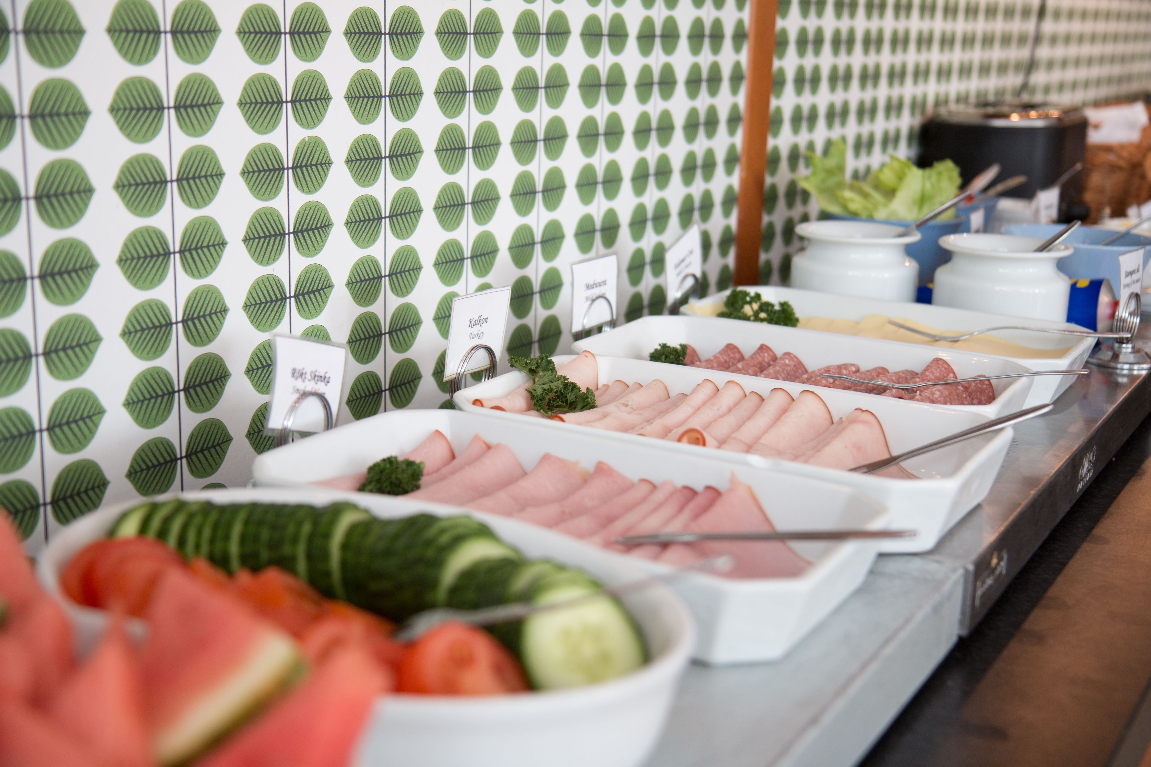 Un bufé con diversas opciones de comida, incluyendo carnes, verduras y ensaladas.