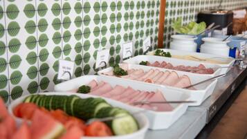 Un bufé con diversas opciones de comida, incluyendo carnes, verduras y ensaladas.