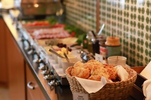 Un bufé con diversas opciones de comida, incluyendo scones, salsas y aderezos.