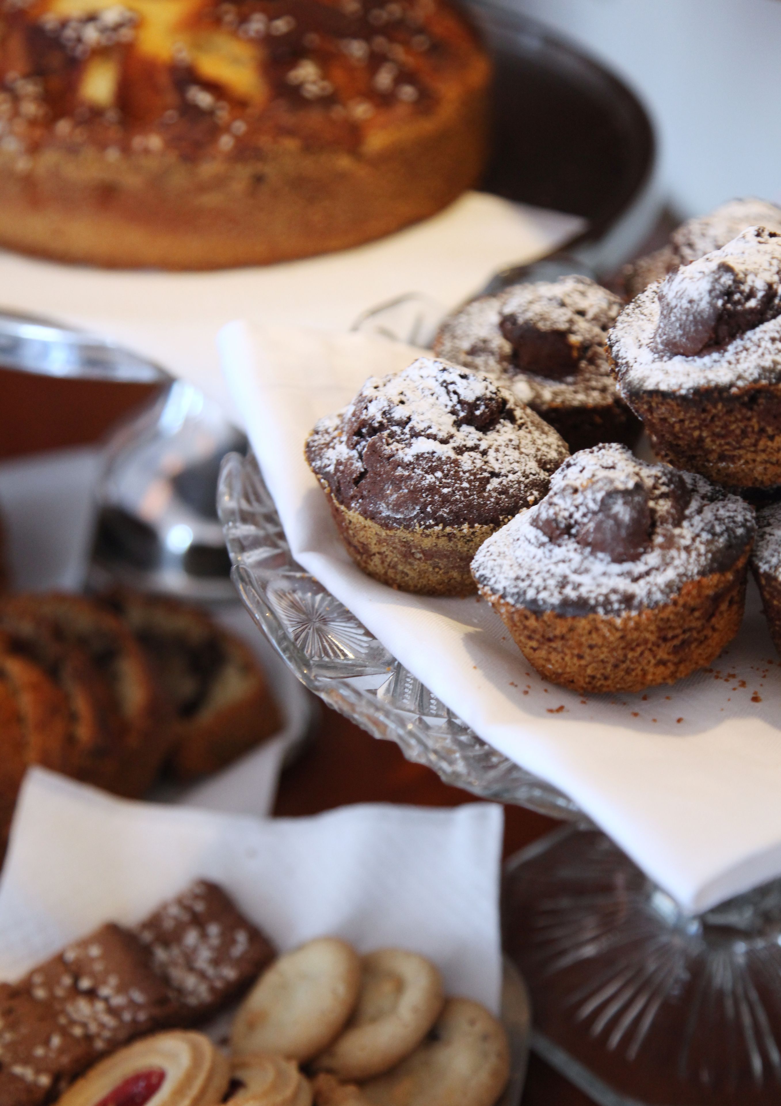 Tarjotin, jossa on erilaisia leivonnaisia, kuten muffinsseja ja keksejä.