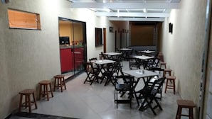Un comedor con mesas y sillas, una barra y vistas al exterior.