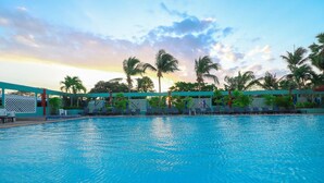A swimming pool with lounge chairs and palm trees in the background. - HUA HIN GRAND HOTEL AND PLAZA (Hua Hin)
