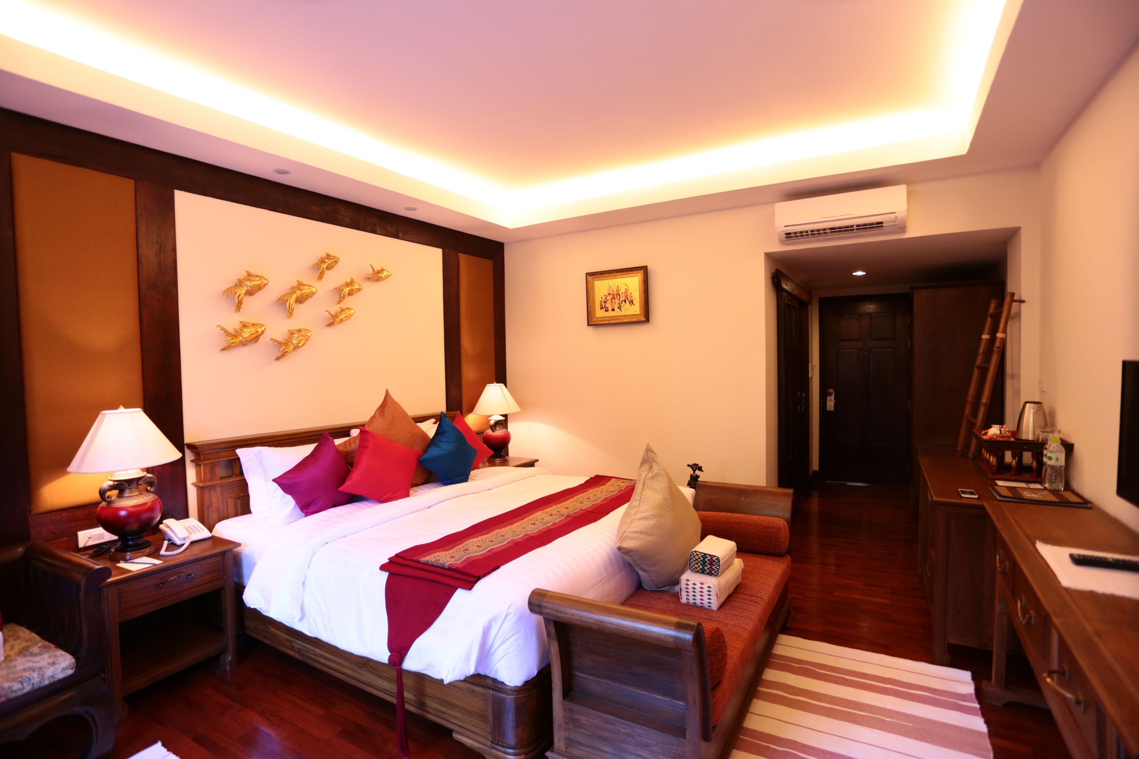 A hotel room with a large bed, bedside tables, a desk, and a chair.