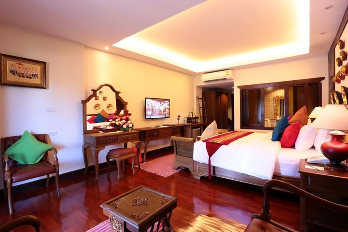 Una habitación de hotel con cama, escritorio, silla y televisor.