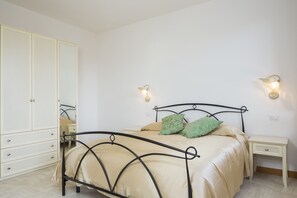 A bedroom with a bed, nightstands, a wardrobe, and wall sconces. - I Tetti di Siena (Siena)