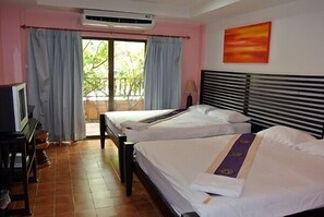 Habitación de hotel con dos camas, televisión y ventana con cortinas.