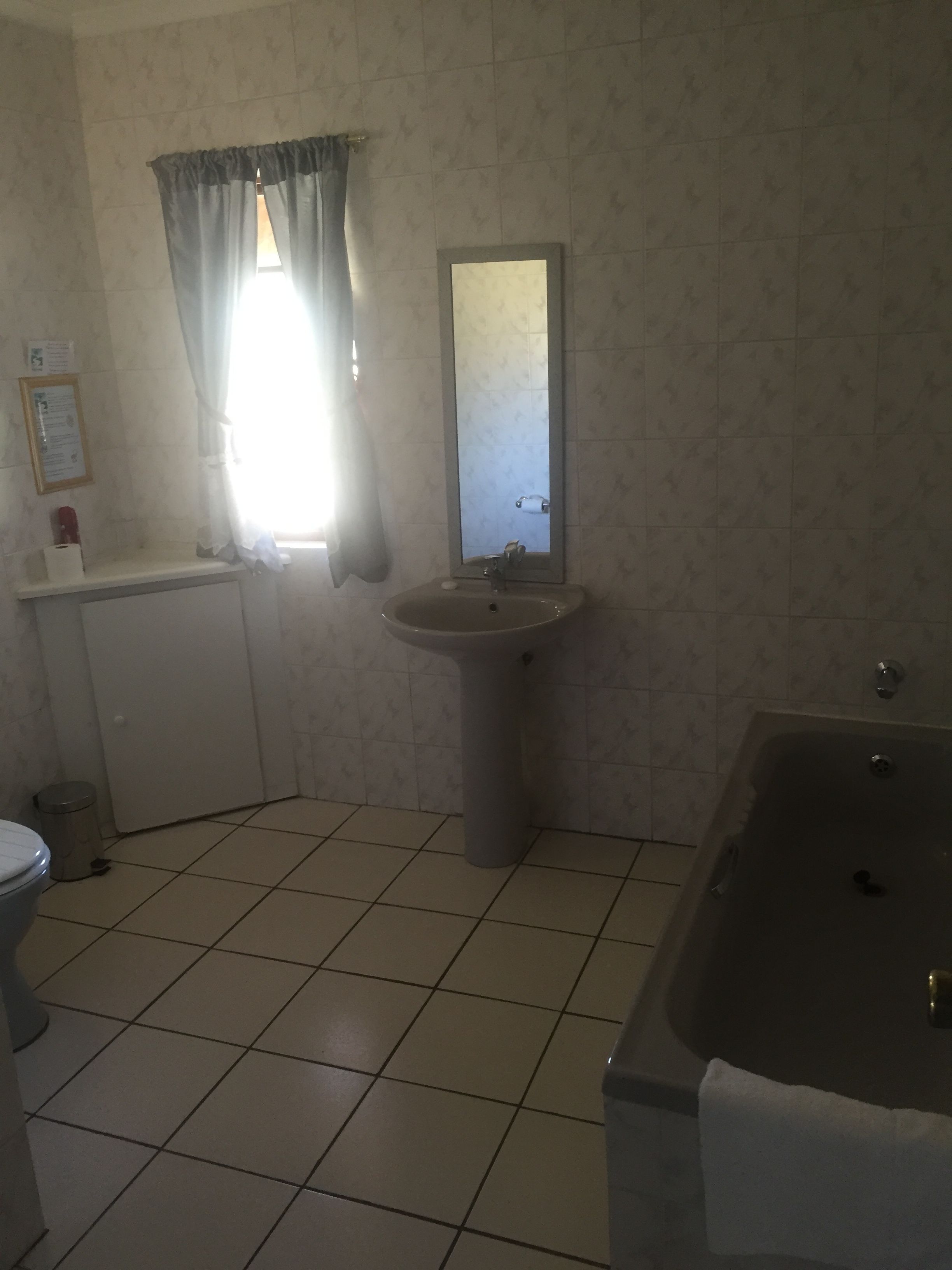 A bathroom with a sink, mirror, toilet, and bathtub.