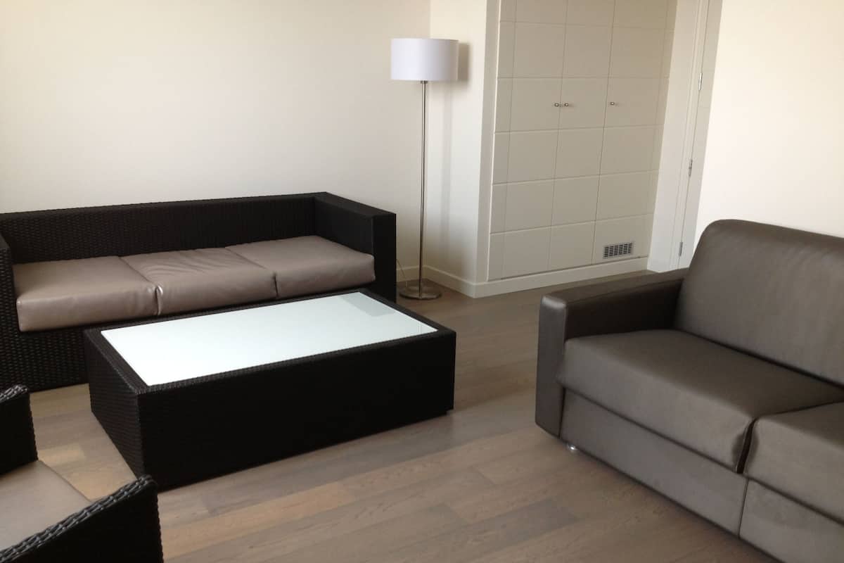 A living room with a sofa, a coffee table, and a floor lamp.