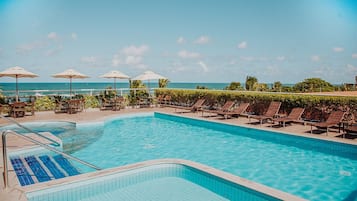 Een buitenzwembad, parasols voor strand/zwembad