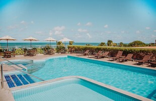 Una piscina al aire libre, sombrillas, sillones reclinables de piscina
