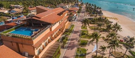 A resort with a swimming pool, beach access, and a view of the ocean.