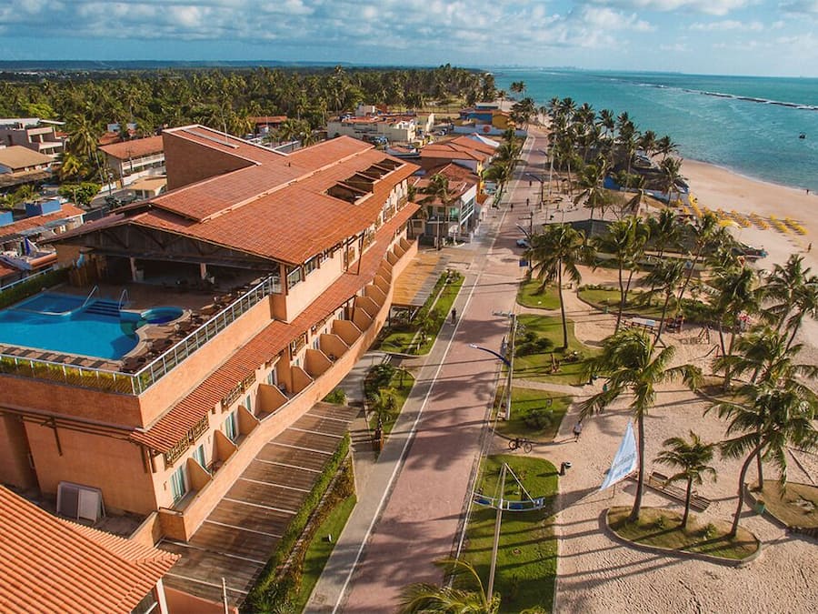 Un resort con piscina, acceso a la playa y vista al océano.