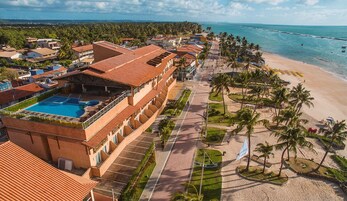 Un resort con piscina, acceso a la playa y vista al océano.