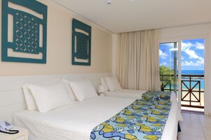 Habitación de hotel con dos camas, teléfono y vista al océano.